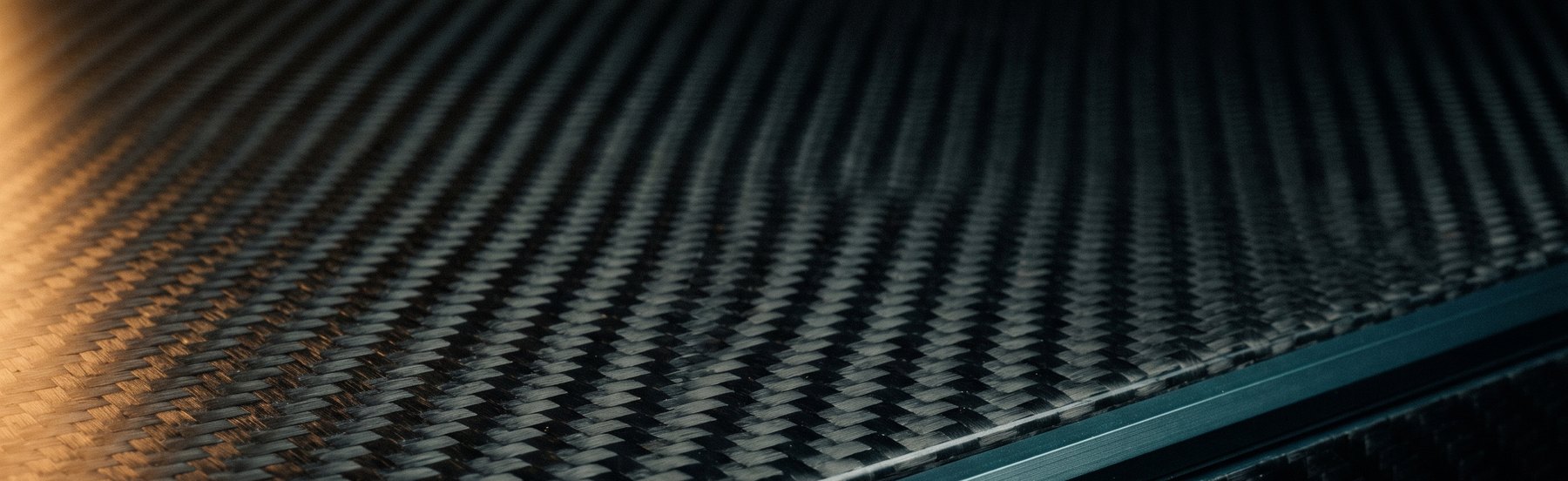 Macro of woven carbon fibre twill under raking light