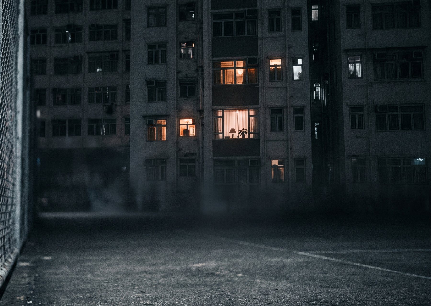 Apartment windows overlooking a dark court at night
