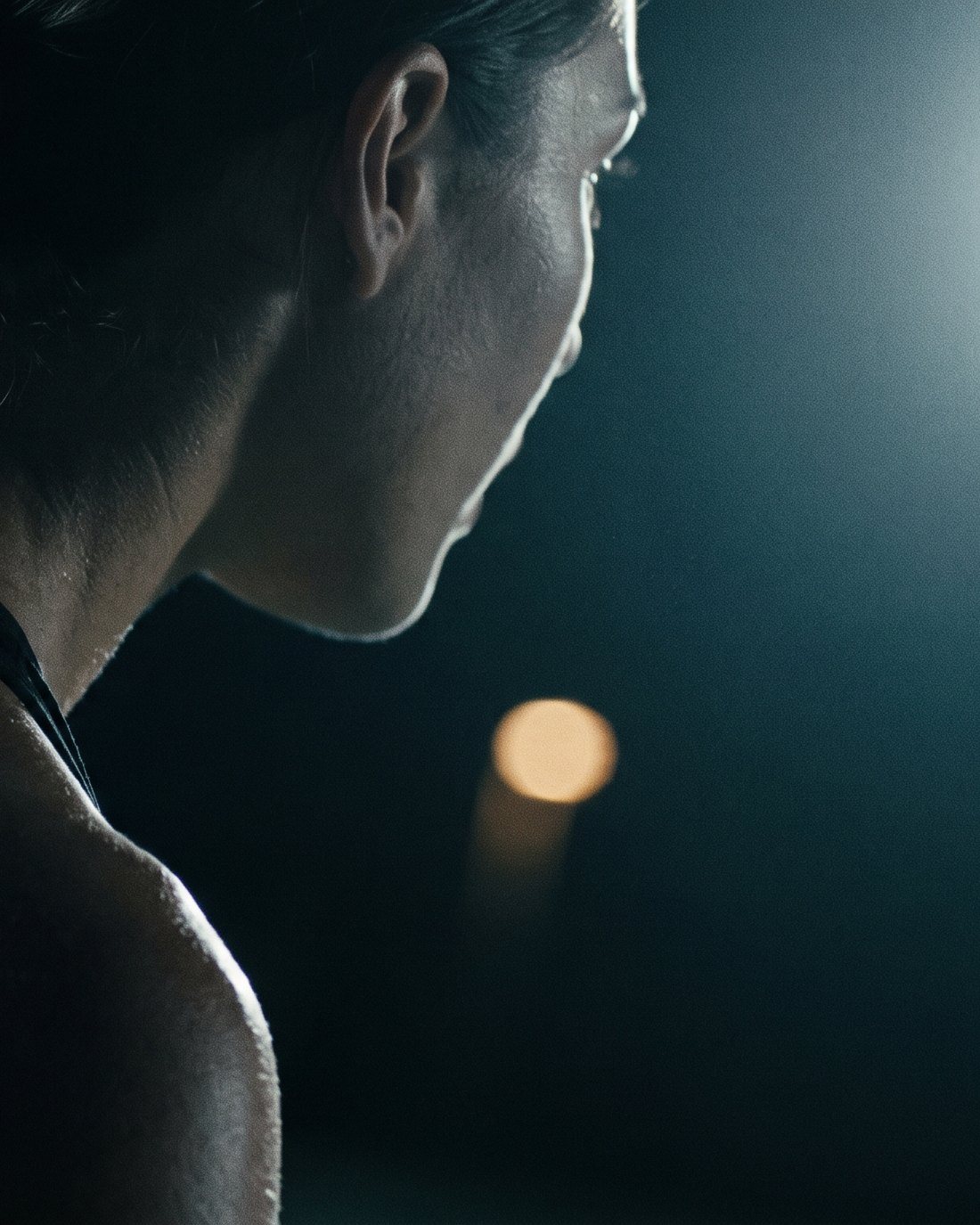 Close crop of a player's shoulder and back mid-rotation under floodlight